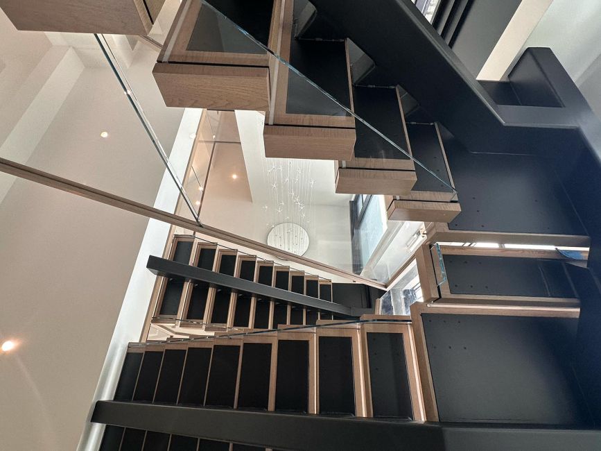 Multi-level modern open riser staircase with wood steps and clear glass railings