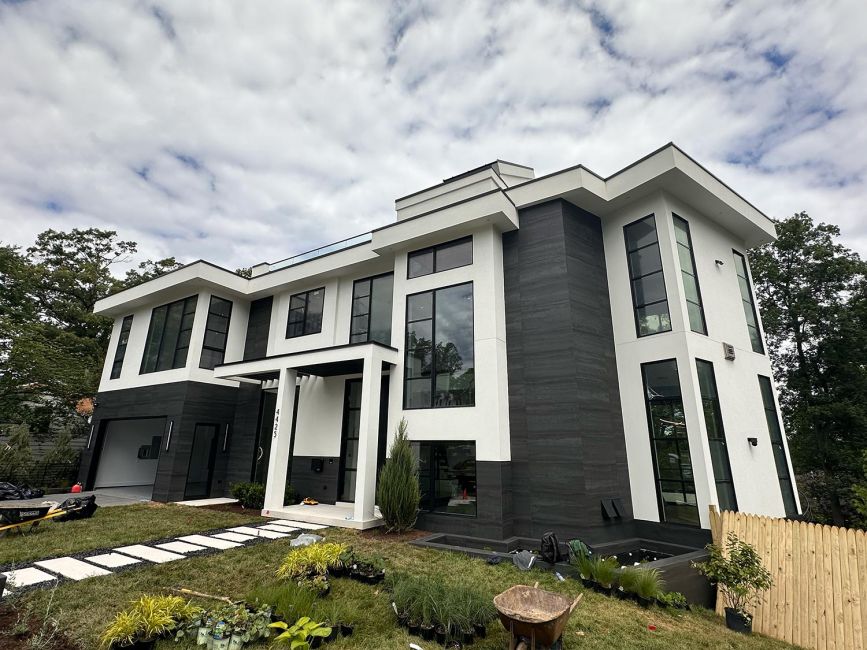 Front exterior view of a custom contemporary home with black and white structural panels