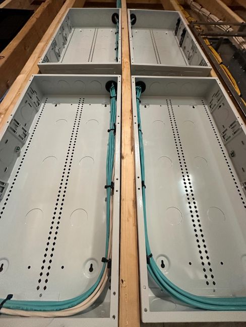 Interior view looking down into two empty white metal structured wiring enclosures